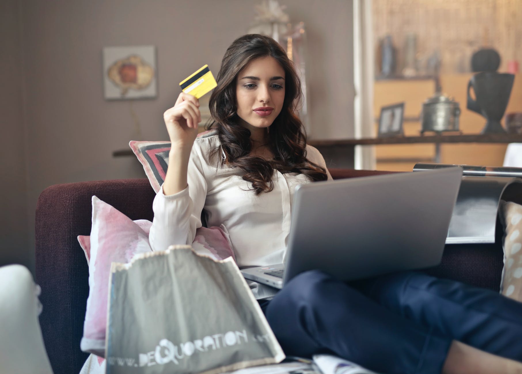 Motorola woman holding card while operating silver laptop 