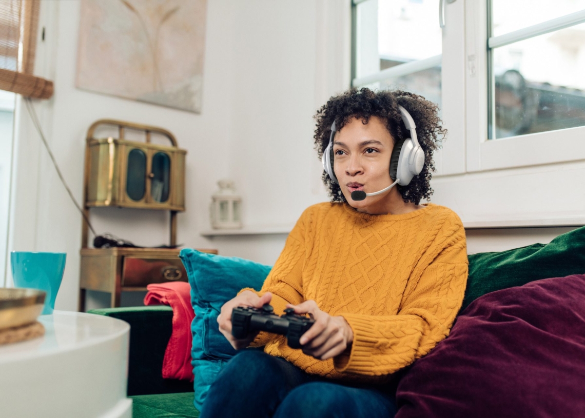 Portrait of a young African American woman playing video games at home and having fun.