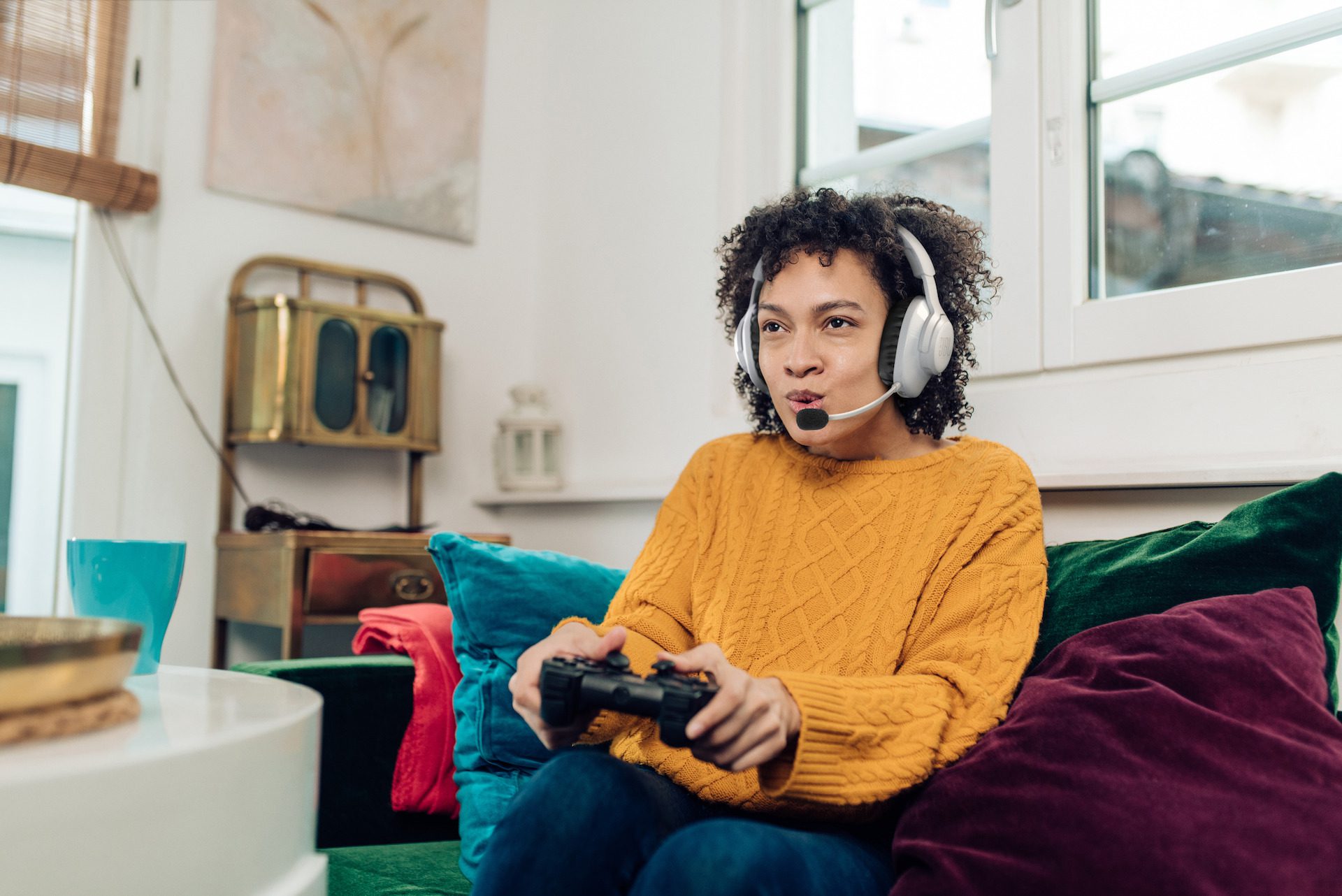 Portrait of a young African American woman playing video games at home and having fun.